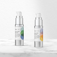 Rulo Everyday Serum and Ageless Serum bottles on a marble surface, featuring sleek silver pumps and minimalist white labels with colorful overlapping circle designs